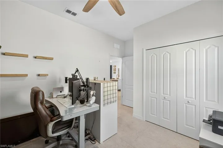 Bedroom featuring a tray ceiling, ceiling fan, and light tile patterned floors
