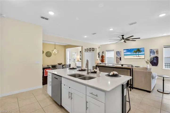 Kitchen featuring a center island with sink, a ceiling fan, light tile patterned flooring, light countertops, and recessed lighting