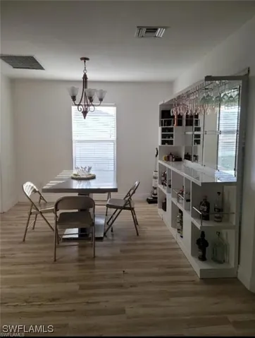 Dining room with light wood-style flooring and a chandelier