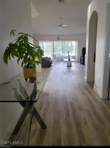 Hall featuring light wood-style flooring and arched walkways