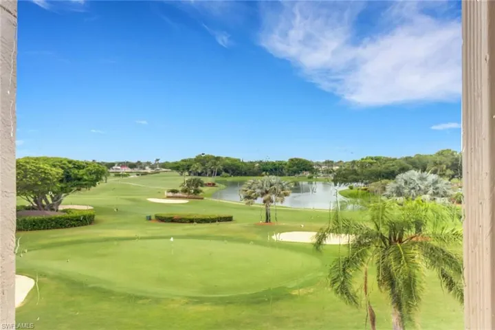 View of home's community featuring a water view, view of golf course, a yard, and a putting area