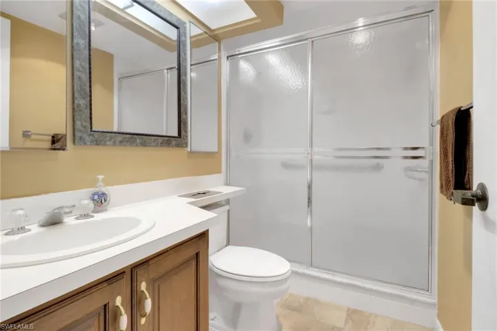 Full bathroom with vanity, a stall shower, and toilet