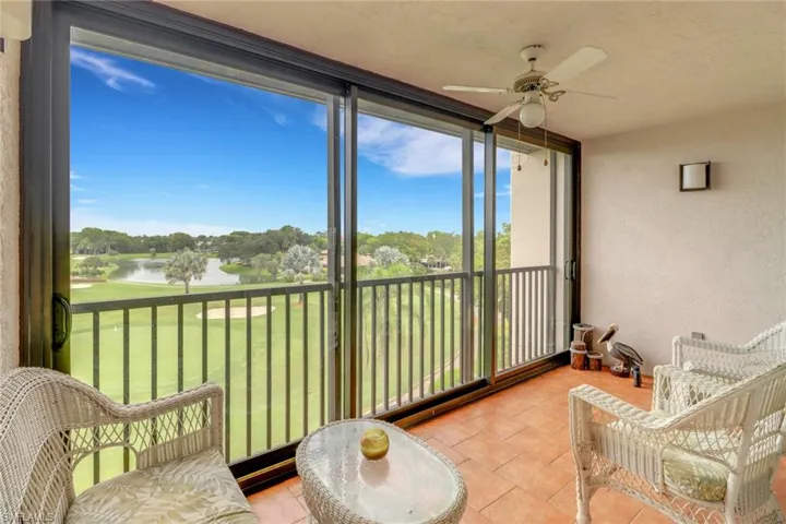 Sunroom featuring a water view, ceiling fan, healthy amount of natural light, and a textured wall