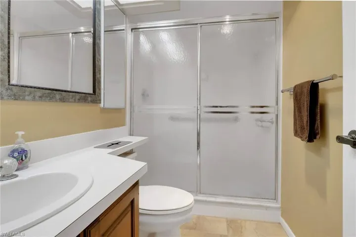 Bathroom with vanity, a stall shower, and toilet
