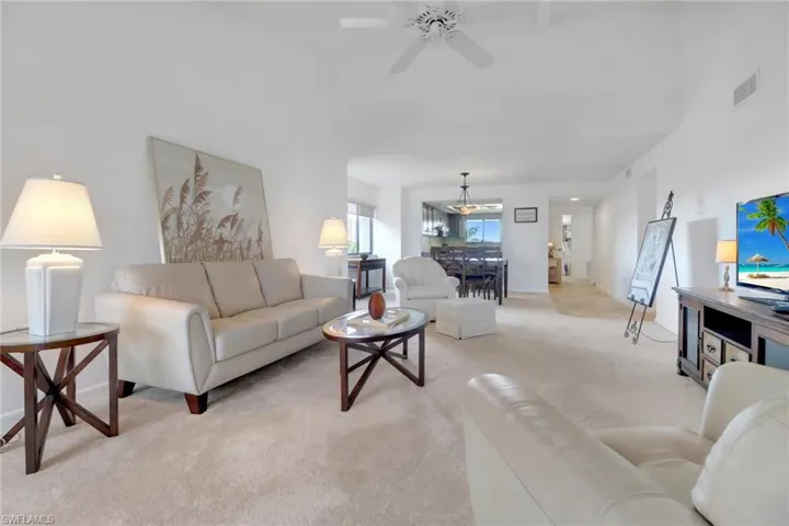 Living room featuring light colored carpet and a ceiling fan
