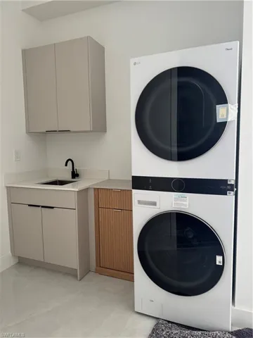 Laundry area with cabinet space and stacked washer / drying machine