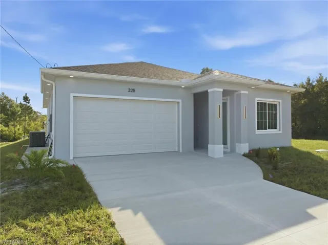 Ranch-style house featuring stucco siding, driveway, an attached garage, a shingled roof, and a front yard