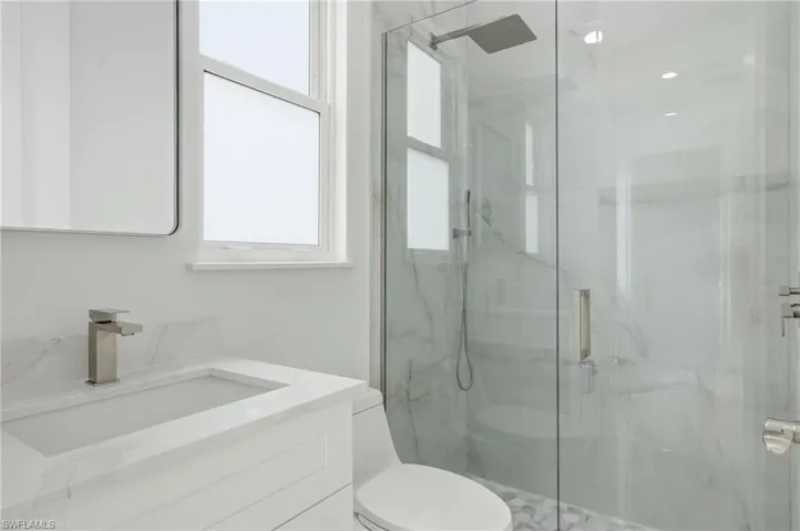 Full bath with vanity and a marble finish shower