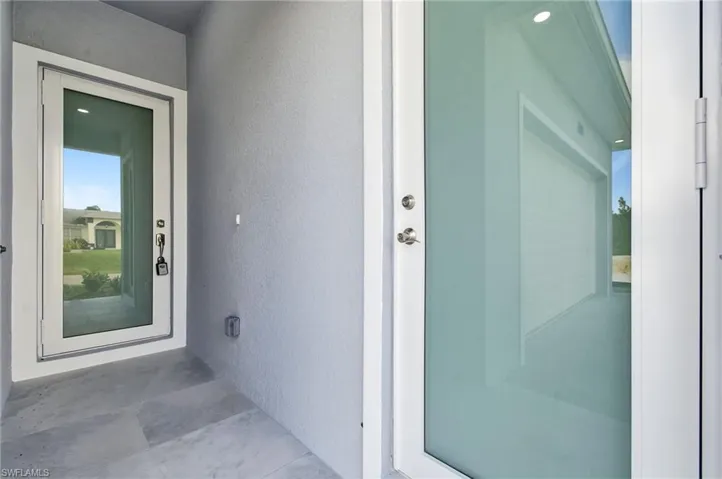 Doorway to property featuring stucco siding