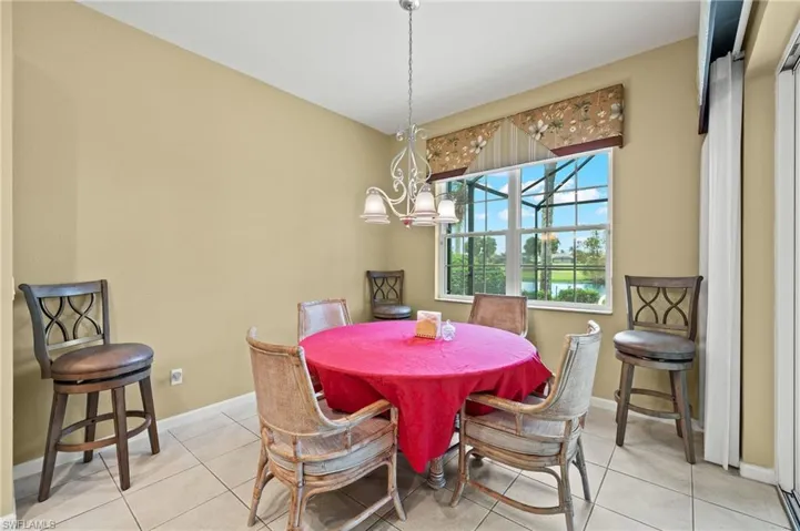 Dining space with a notable chandelier and light tile patterned flooring