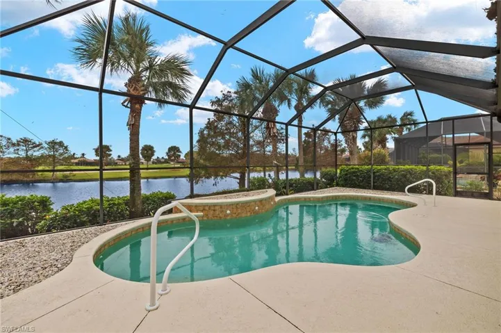 View of pool featuring a patio area, a water view, and a lanai
