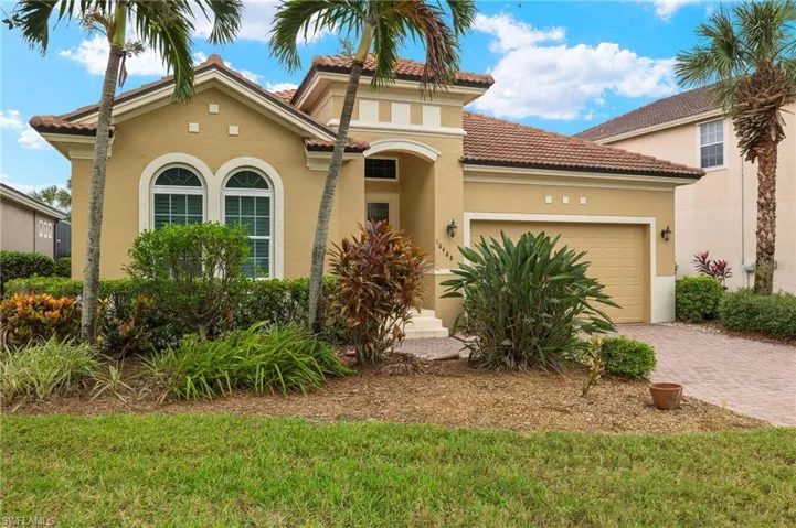 Mediterranean / spanish-style home featuring a front lawn and a garage