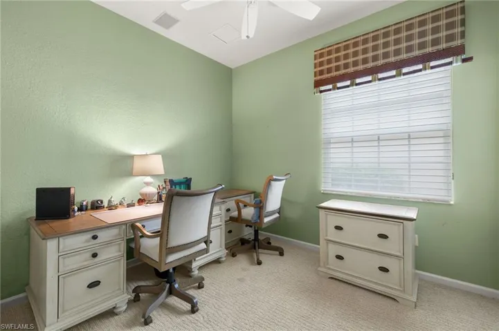 Office space featuring light colored carpet and ceiling fan
