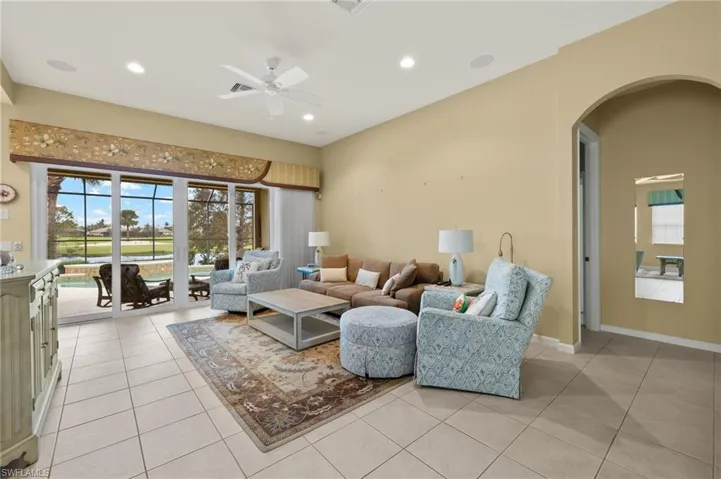 Living room featuring a wealth of natural light, light tile patterned floors, and ceiling fan