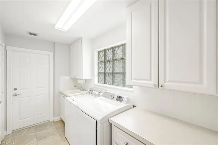 Spacious Laundry Room with utility sink, counter space and ample storage cabinets
