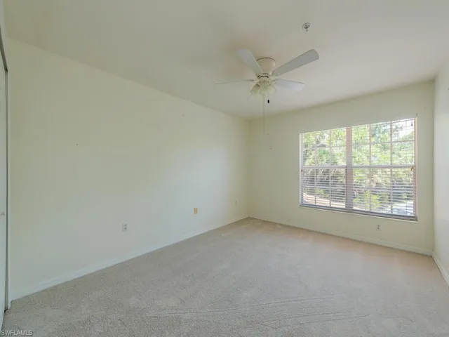 Carpeted spare room featuring ceiling fan