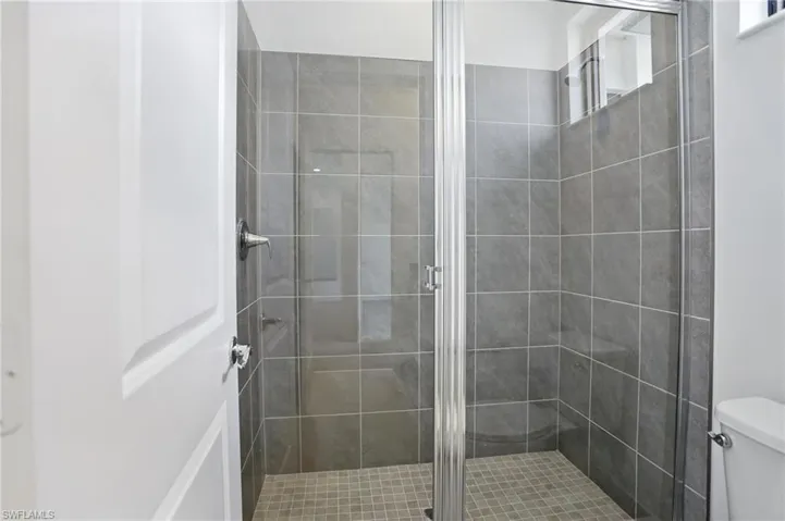 Full bath with a shower stall and toilet