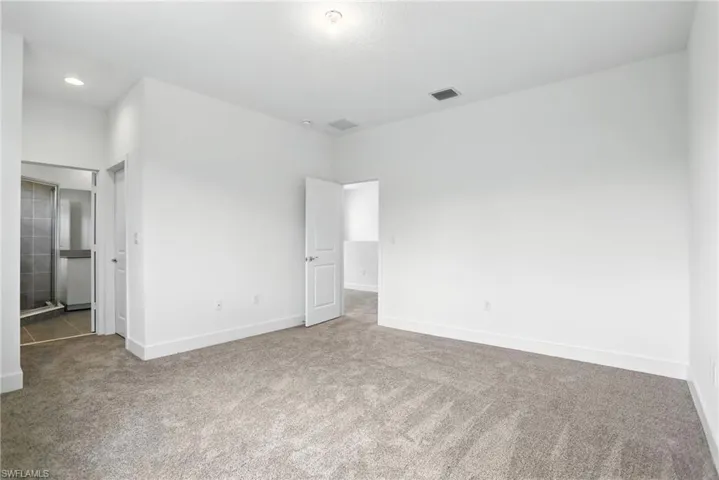 Unfurnished bedroom with carpet and ensuite bath