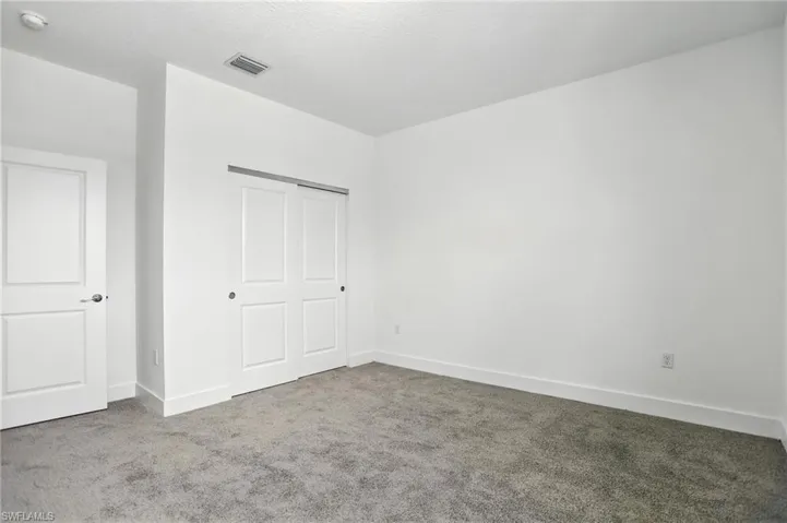 Unfurnished bedroom featuring carpet, a closet, and a textured ceiling