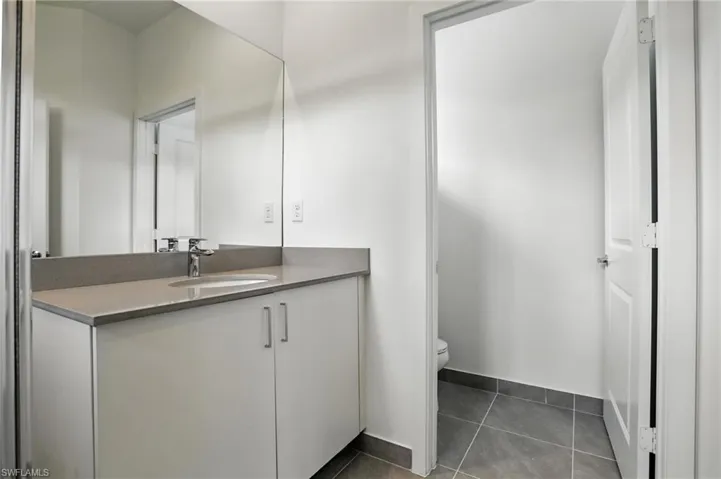 Bathroom with vanity and dark tile patterned floors