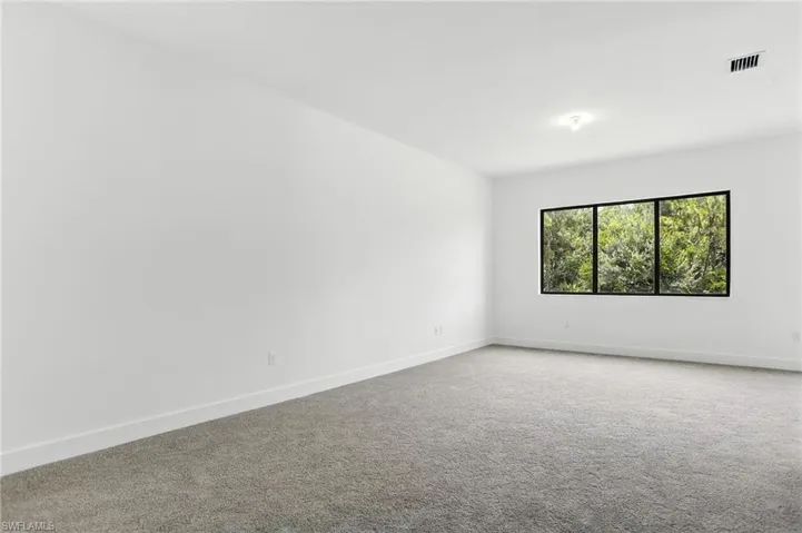 Carpeted empty room featuring baseboards