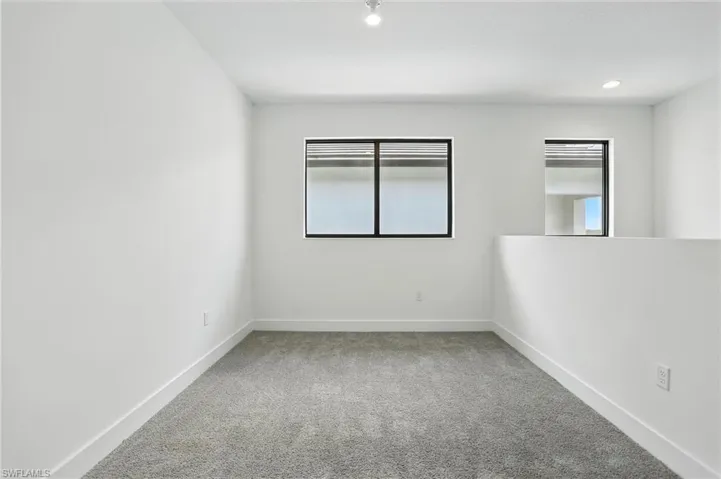 Empty room featuring light colored carpet and baseboards