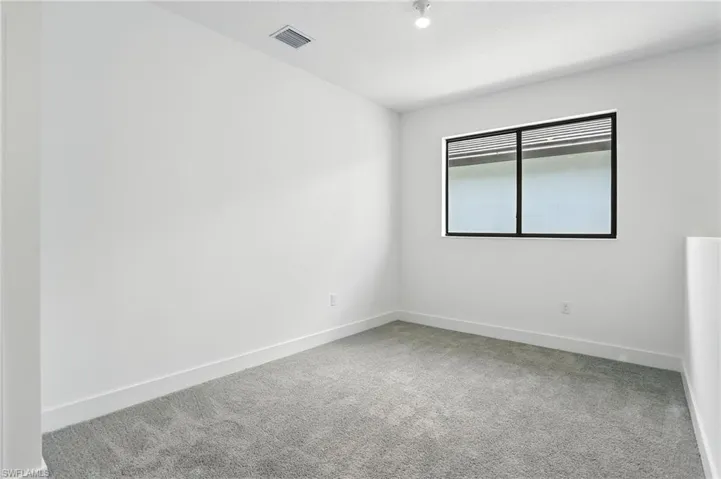 Empty room with carpet flooring and baseboards