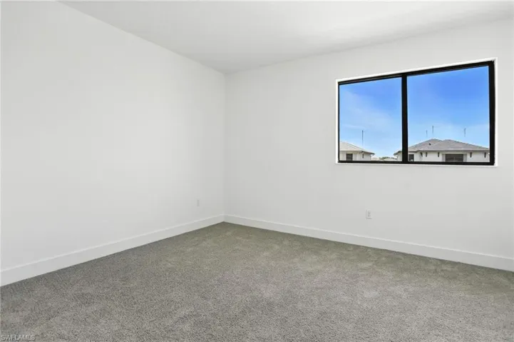 Empty room with carpet flooring and baseboards