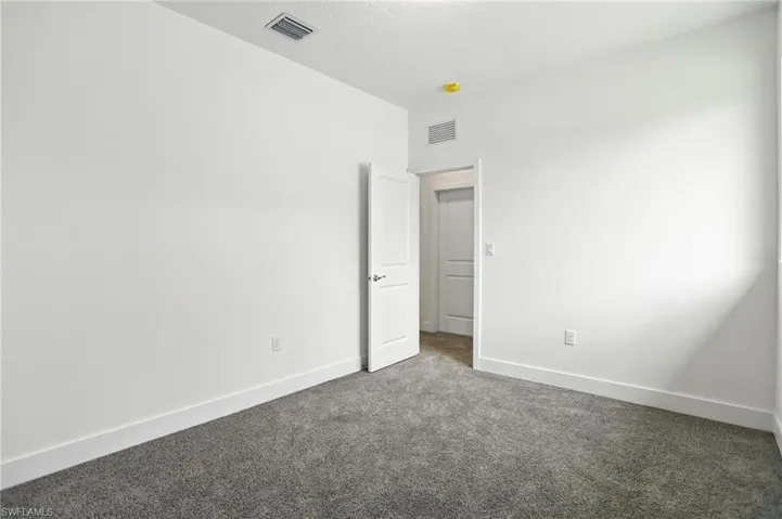 Carpeted spare room with baseboards