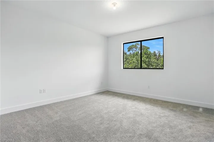 Carpeted empty room with baseboards