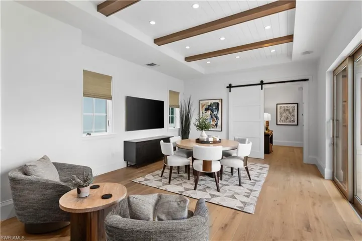Dining space featuring a barn door, light wood-style flooring, baseboards, recessed lighting, and wooden ceiling with exposed beams