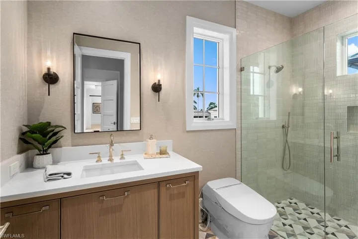 Full bath with vanity, a shower stall, and toilet