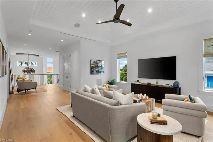 Living room featuring recessed lighting, light wood-type flooring, ceiling fan, a chandelier, and baseboards