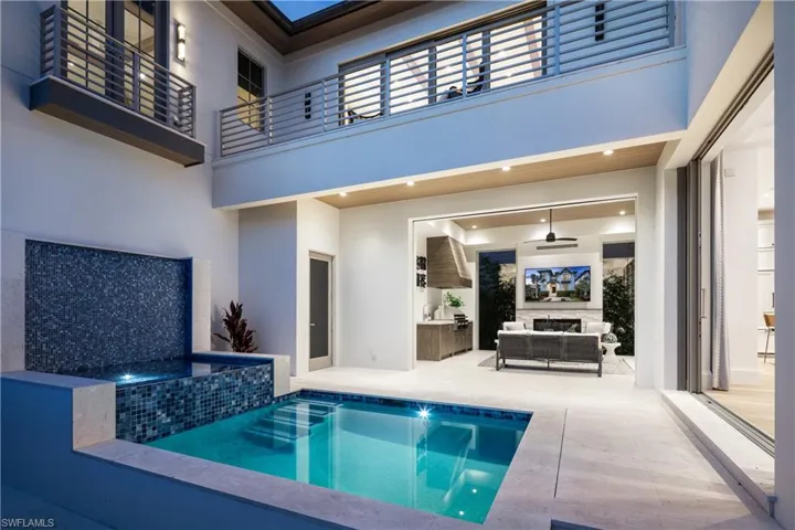 View of pool with an outdoor living space with a fireplace, a patio area, and a pool with connected hot tub