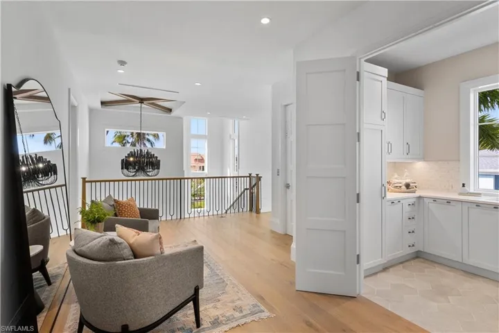 Sitting room featuring a chandelier, recessed lighting, light wood-type flooring, and an upstairs landing