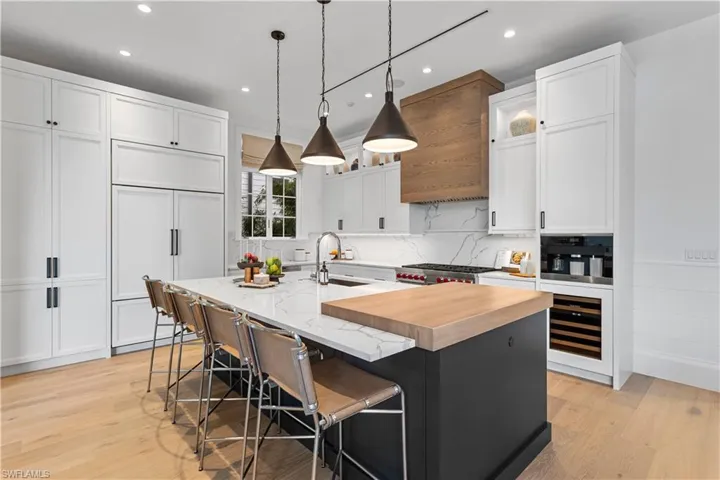 Kitchen featuring recessed lighting, light wood-type flooring, paneled built in refrigerator, and white cabinets