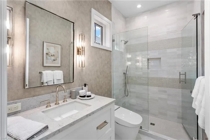 Full bathroom with vanity, a stall shower, and toilet