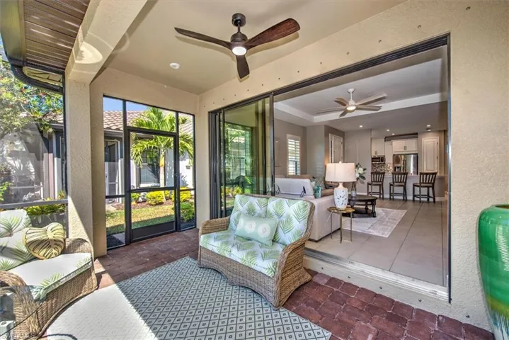 Sunroom / solarium with a tray ceiling and a ceiling fan