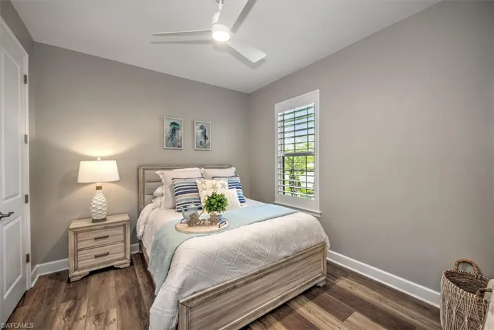 Bedroom with baseboards, ceiling fan, and dark wood-style flooring
