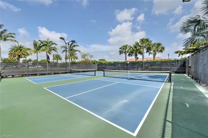 View of tennis court with community basketball court and fence