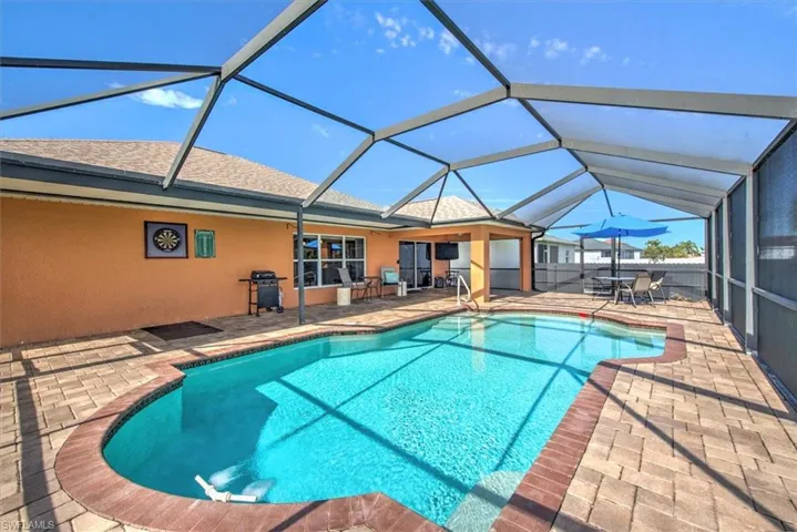 View of pool with grilling area, a lanai, and a patio area