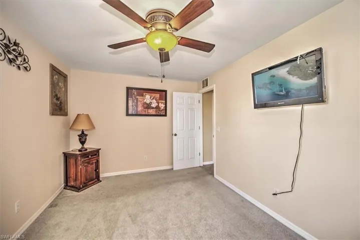 Empty room featuring ceiling fan and light carpet