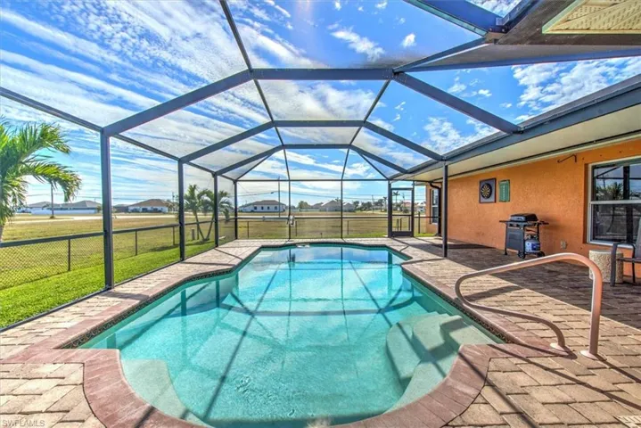 View of swimming pool with area for grilling, a yard, a lanai, and a patio
