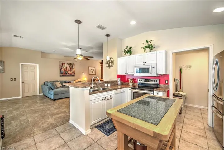 Kitchen with stainless steel appliances, sink, white cabinets, and kitchen peninsula