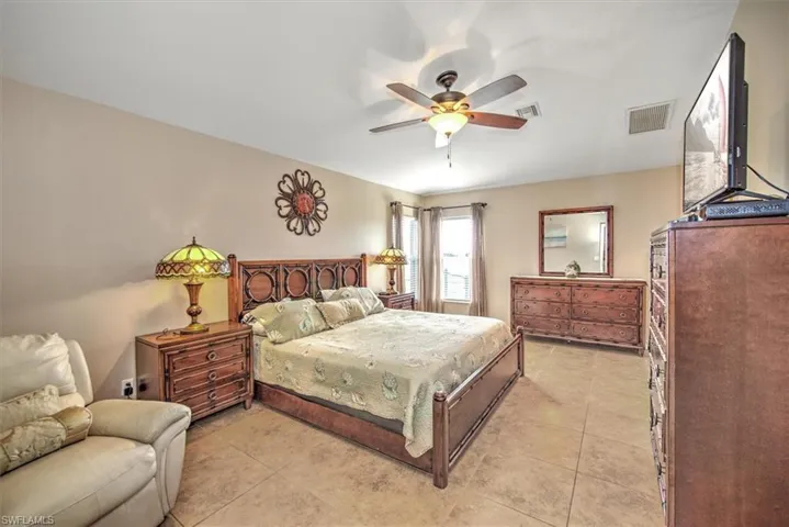 Bedroom with light tile patterned floors and ceiling fan