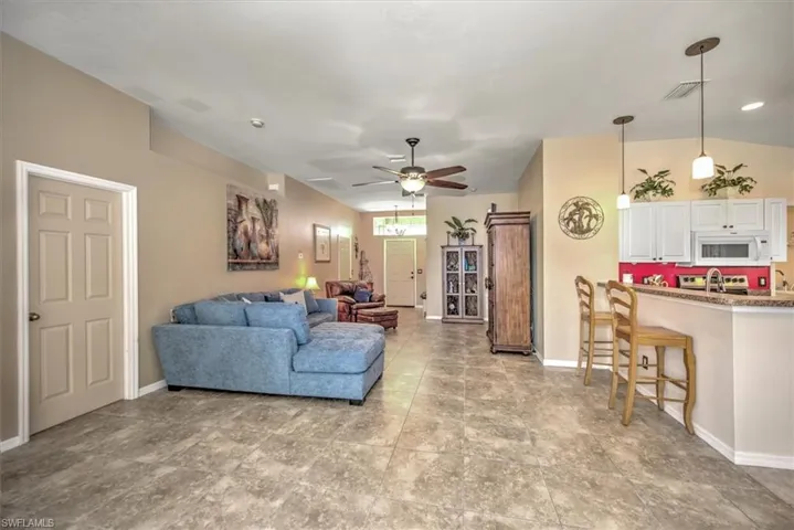 Living room featuring ceiling fan and sink
