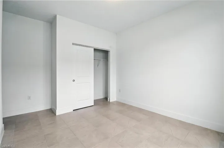 Unfurnished bedroom with a closet and baseboards