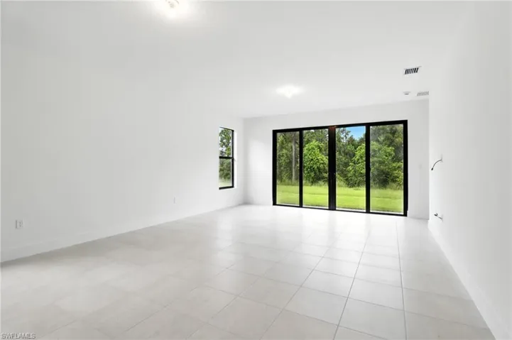 Unfurnished room with plenty of natural light and light tile patterned flooring