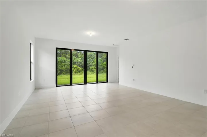 Unfurnished room featuring light tile patterned floors and baseboards
