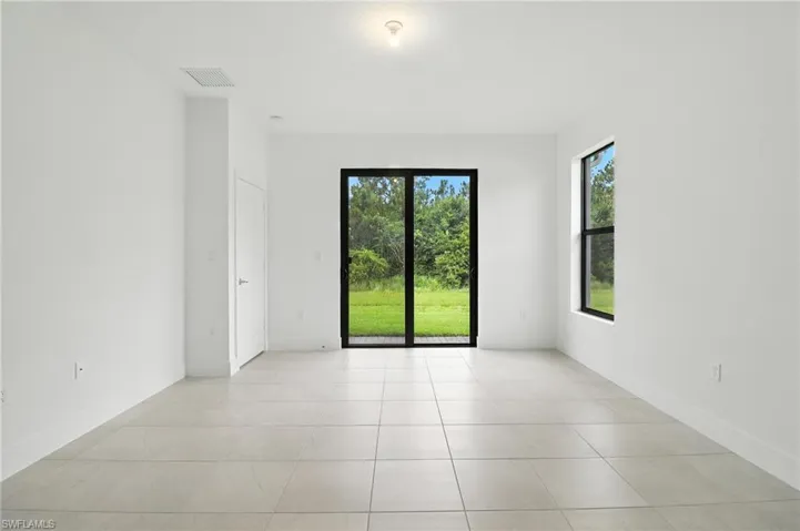 Unfurnished room featuring light tile patterned flooring and baseboards